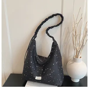 Close-up detail of black star print hobo tote bag with scrunchie strap and stylish label.