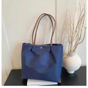 Blue Oxford cloth shoulder tote bag detail showing large capacity and elegant daily commute style.