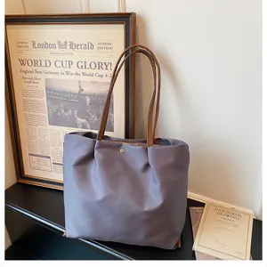 Detailed view of the casual lavender nylon tote bag with brown straps and vintage background.