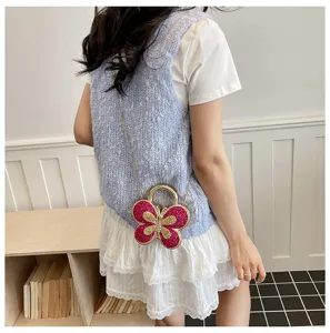 Detailed shot of a sweet butterfly-shaped crossbody bag with glittering pink wings and a chic gold chain.