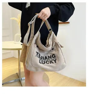 Detailed view of casual canvas shoulder bag with letter print and adjustable strap.
