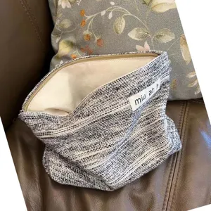 Schwarze Jacquard Kosmetiktasche Detailansicht, tragbare Reißverschlusstasche mit Label.