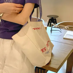 Korean style large capacity canvas tote bag with stylish letters print and striped shoulder strap.