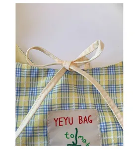 Close-up detail of the Japanese style plaid canvas handbag, featuring cute bows and sewn labels.