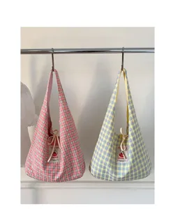 Detailed view of cute Japanese plaid canvas tote bags hanging on rack, showing cute tags.