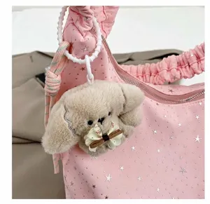 Close up detail showing the cute plush puppy pendant and pink star print tote bag strap.