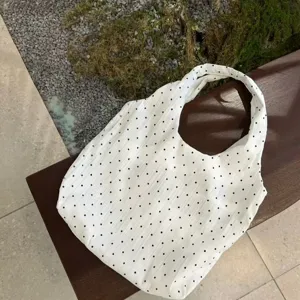 White canvas tote bag with black polka dots, casual shoulder bag, detailed product view.