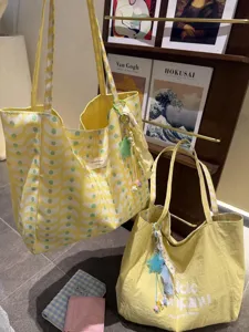 Yellow canvas tote bag detail, casual commuter shoulder bag with wave pattern and cute charms.
