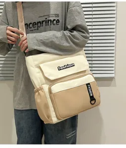 Canvas shoulder bag detail showing multi-pocket design, color block style and durable strap.