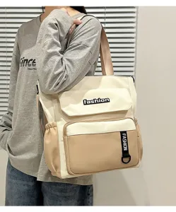 Canvas crossbody bag detail showing beige white color block, spacious front pocket and sturdy strap.
