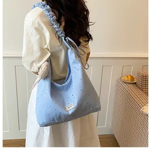 Light blue starry print slouchy canvas tote bag with ruffled strap and cute charm detail.