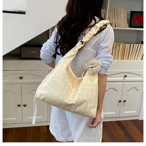 Casual yellow polka dot canvas tote bag with slouchy shoulder strap and cute plush dog pendant.