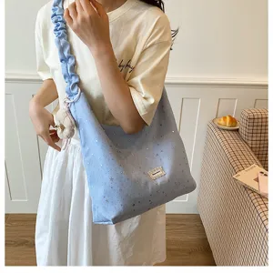 Detail view of the light blue star print tote bag with stylish pleated strap and cute charm.