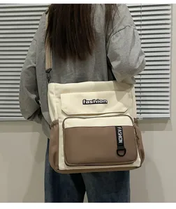 Detail view of casual canvas shoulder bag with contrast color, front pockets and adjustable strap.
