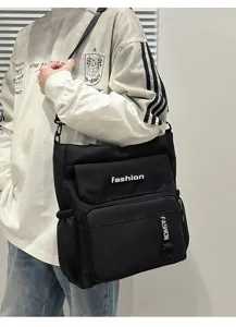 Detailed shot of casual black canvas crossbody bag with multi pockets and stylish fashion text design.