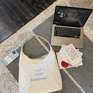 Stylish pleated canvas shoulder bag featuring chic embroidered lettering for daily use.