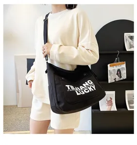 Black canvas crossbody tote bag for women, large capacity shoulder school bag with letters.