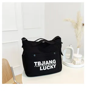 Detail view of the black canvas shoulder tote bag with letters print and large capacity for daily use.