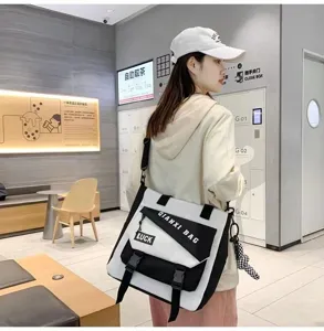 Vue rapprochée du sac bandoulière en toile étanche avec un design contrasté noir et blanc.