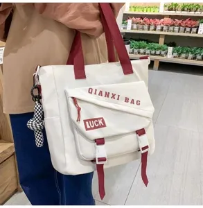 Vue détaillée du sac cabas en toile, sac à bandoulière en nylon imperméable avec sangles rouges.