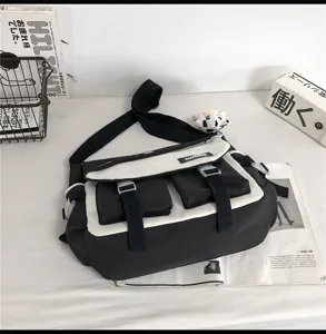 Borsa a tracolla in tela bicolore bianco e nero con tasche multiple e fibbie resistenti.