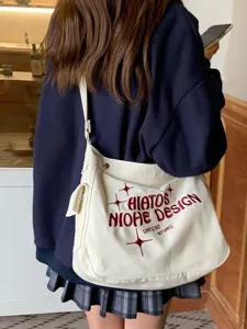 Canvas crossbody bag detail showing red embroidery and large interior capacity for students.