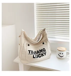 Canvas shoulder bag for women, large capacity tote bag with letter print, casual daily use.