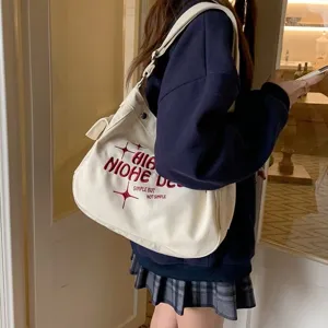 Canvas shoulder crossbody bag detail, casual style with red embroidery, spacious and practical.
