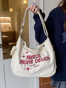 Detailed shot of casual canvas shoulder bag with embroidered English lettering and star design.