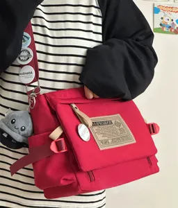 Casual red canvas messenger bag large capacity retro crossbody bag for daily student commuting.