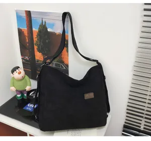 Vue détaillée du sac bandoulière en velours côtelé noir, fourre-tout décontracté.