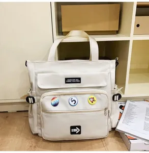 Detailansicht der cremeweißen Canvas-Tasche mit großem Fassungsvermögen und Abzeichen.