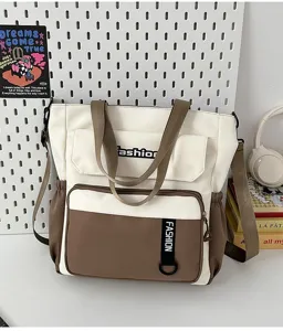Detail view of the canvas tote bag showing contrast color design, pockets and shoulder straps.