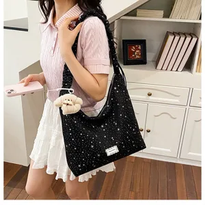 Casual starry print black hobo shoulder bag with cute plush pendant and pleated strap.