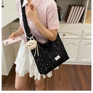 Detail shot of the star-printed tote bag featuring a ruffled strap and cute plush charm.