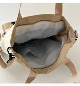 Canvas shoulder bag interior detail showing spacious compartment and multiple inner pockets.