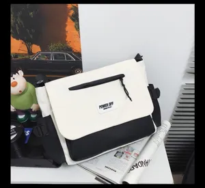 Detailed view of the black and white nylon messenger bag, showcasing the front flap and patch.
