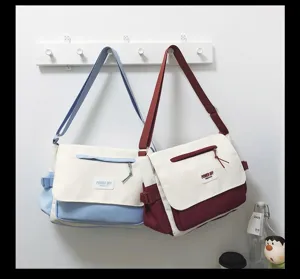 Nylon messenger bag detail on wall hook, showing contrast color design and front pocket.