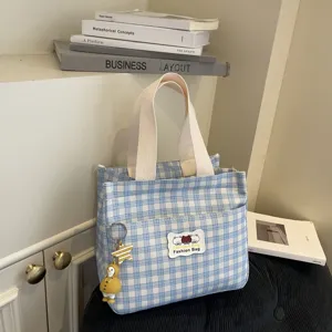 Borsa cosmetica a quadri blu e bianchi con manici, toppa con orsetto e pratica tasca frontale.