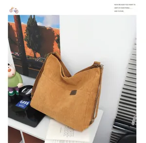 Vue détaillée du sac porté épaule en velours côtelé marron montrant la texture du tissu.