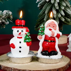 Dettagli di candele natalizie con simpatico design da pupazzo di neve e Babbo Natale per decorare.