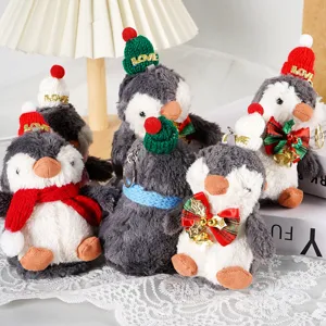 Dettaglio di graziosi ciondoli in peluche a forma di pinguino di Natale con cappello.