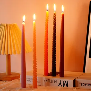Vista dettagliata di candele coniche colorate in una calda e accogliente illuminazione per feste.