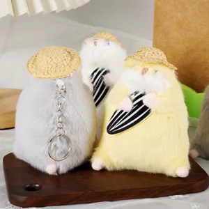 Dettaglio portachiavi peluche criceto carino, ciondolo zaino animale imbottito morbido con cappello.