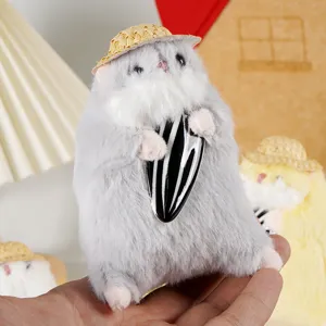 Primo piano dettagliato del simpatico peluche di criceto grigio con cappello e seme.