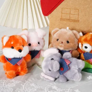 Detailed close-up of assorted cute plush animal pendant toys featuring soft plush fabric and denim bibs.