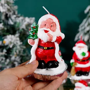 Dettaglio candela Babbo Natale mano tiene decorazione festiva ornamento di cera natalizia.