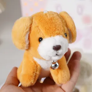 Dettaglio peluche cucciolo carino, ciondolo cane soffice con campanello, accessorio portachiavi.