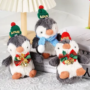 Primo piano del ciondolo in peluche pinguino di Natale carino con sciarpa per borsa.
