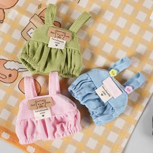 Vista dettagliata di salopette miniatura per bambole in verde, rosa e blu per peluche.